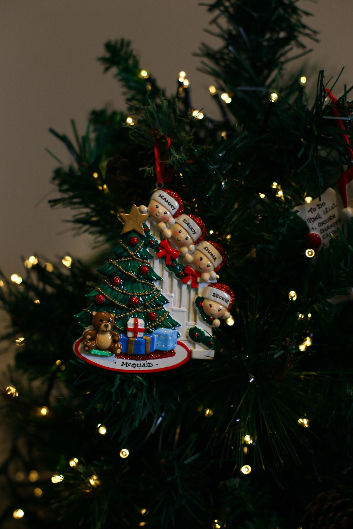 Family Peeking over the Bannisters for a family of 4 Personalised Christmas Decoration hanging on a Christmas tree