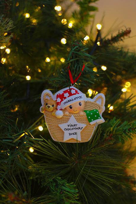 Baby in Basket Red and Green Personalised Christmas Decoration hanging on a Christmas tree