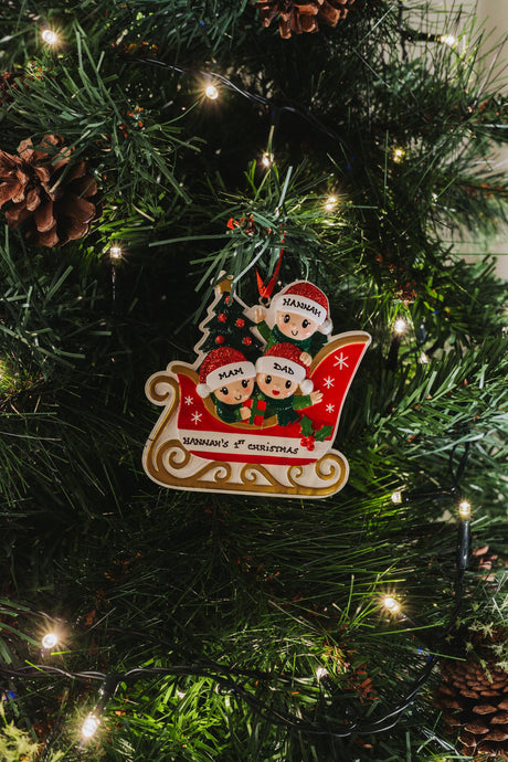 Family in Sleigh with 3 hanging on a Christmas tree