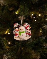 Family Building a Snowman (Family of 4) Personalised Christmas Decoration hanging on a Christmas tree