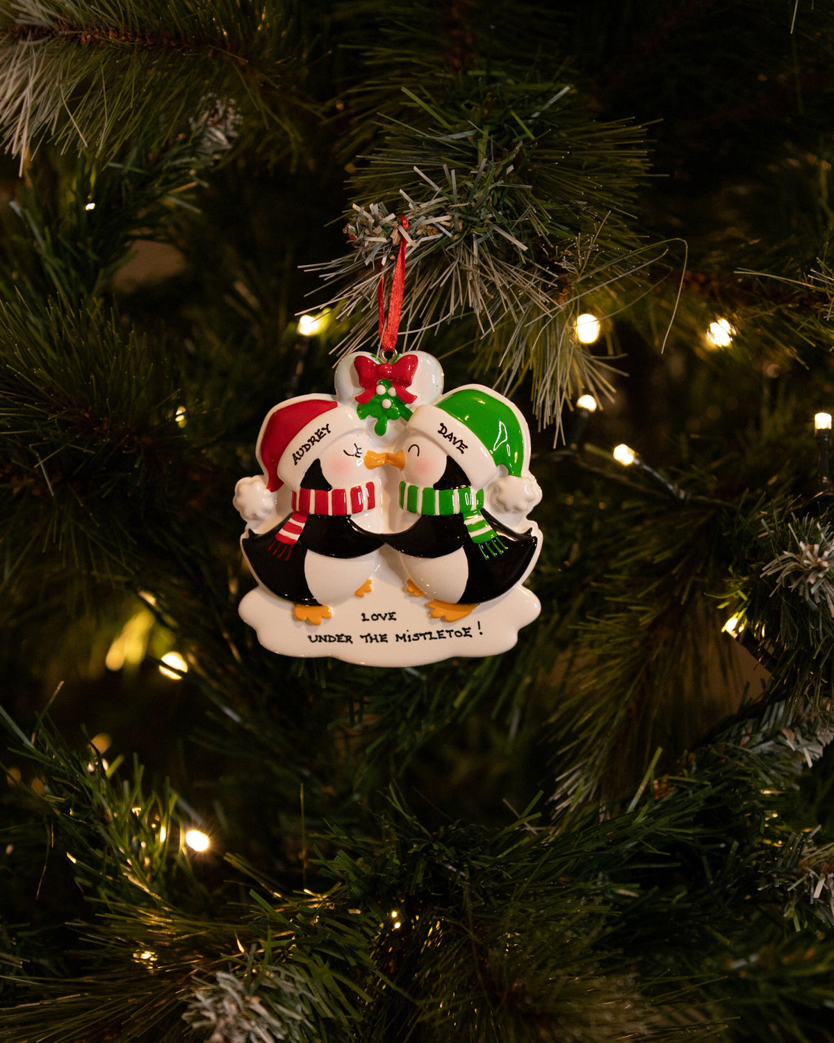 Mistletoe Kissing Penguins Personalised Christmas Decoration hanging on a Christmas tree