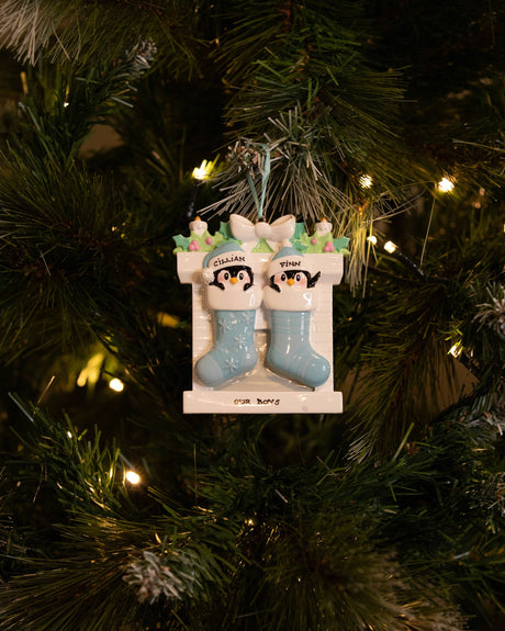 Twin Penguins in Stockings (Blue & Blue) Personalised Christmas Decoration hanging on a Christmas tree