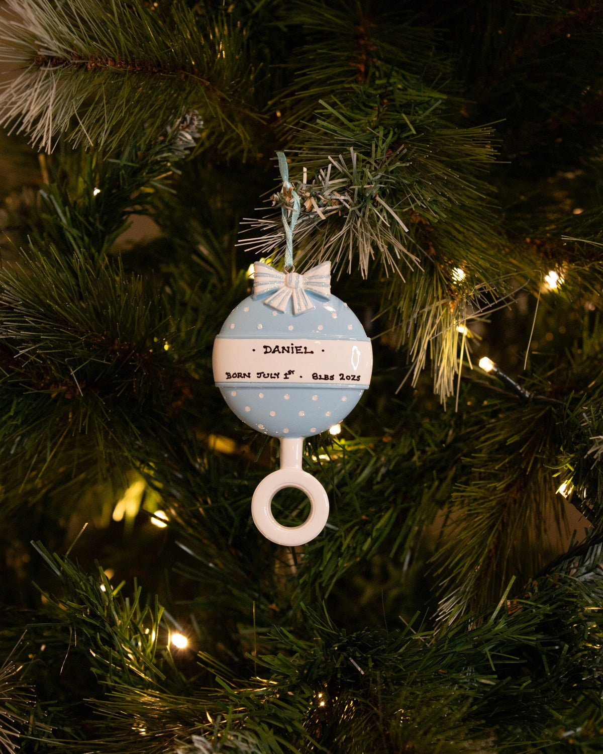Blue Baby Rattle Personalised Christmas Ornament hanging on a Christmas tree