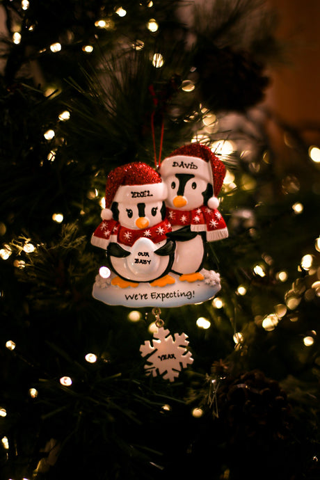 We are Expecting Penguins Personalised Christmas Decoration hanging on a Christmas tree